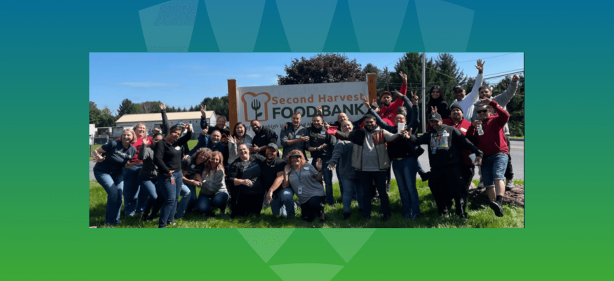  A joyful group of Lineage team members posing outdoors at the Second Harvest Foodbank, celebrating their commitment to community service and team culture. 